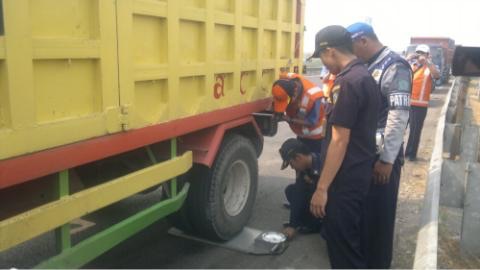 Petugas Jasa Marga saat mengecek truk bermuatan yang akan melintasi tol di pintu masuk tol Porong.