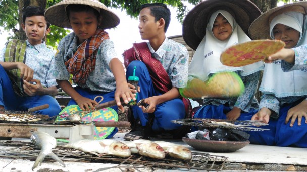 Siswa mengajak gemar makan ikan dengan memanggang ikan di depan Kantor Dinas Kelautan dan Perikanan Sidoarjo