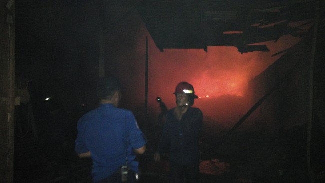 Petugas PMK memadamkan api yang melahap gudang spon di Desa Jogosatru, Sukodono